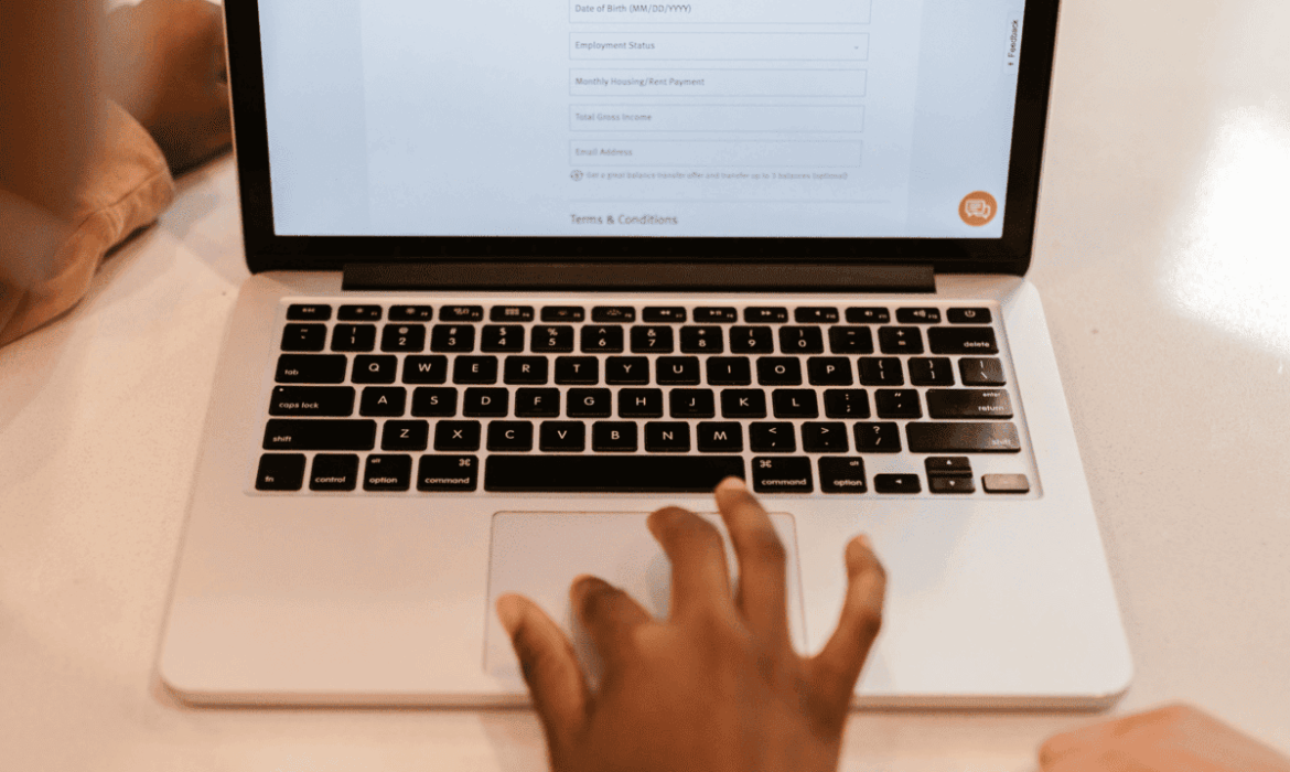 person standing overa laptop as they fill in an online form; to illustrate the importance of customer information protection